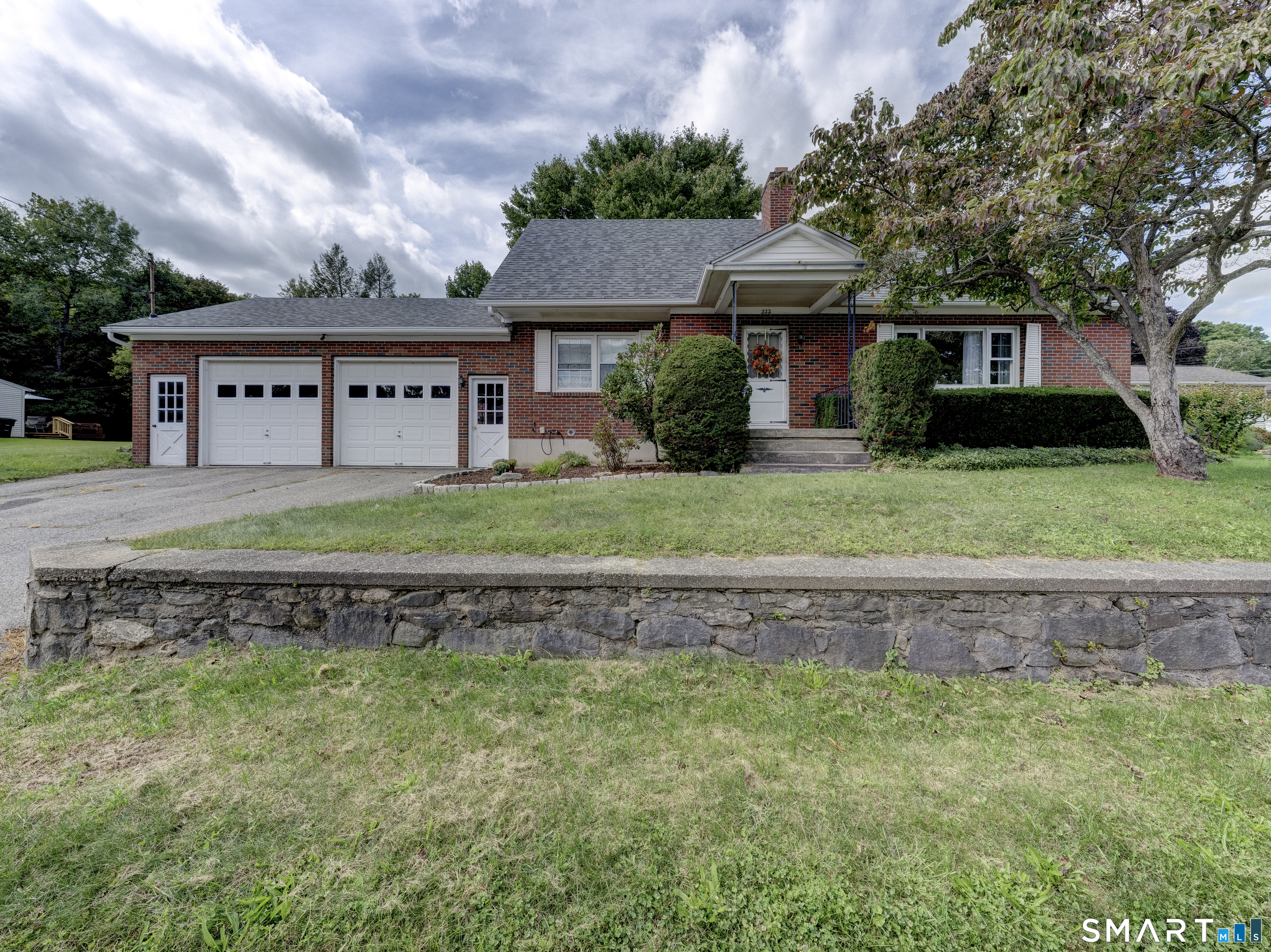 Well-built and meticulously maintained brick Cape situated on a beautiful property on Torrington's desirable west side. This spacious home features a 2-car attached garage plus a separate driveway leading to an additional 2-car garage/barn, perfect for hobbyists, workshop space, storage, or recreational vehicles. Gleaming hardwood floors run throughout the home and continue beneath the visible carpeting. The main level offers generously sized rooms, including a cozy fireplace with gas log insert, a private office with its own exterior entrance, and a welcoming foyer with privacy doors separating the main and upper levels. The second floor is ideal for multigenerational living, featuring a kitchenette, full bath, two bedrooms (one currently used as a living room), abundant closet space, and additional storage in knee-wall attic areas. The partially finished lower level includes a second fireplace, partial bath and laundry. There is extensive workshop space in the unfinished area. Currently heated by natural gas, the home retains the hookups for easy reconnection to oil heat if desired. Electrical includes generator hookup. Generator not included.  Major updates include replacement windows within the last 10 years and a roof that is only one year old. This estate property is being sold as-is but reflects years of exceptional care and pride of ownership. A rare opportunity offering flexible living space, outstanding storage, and endless possibilities.