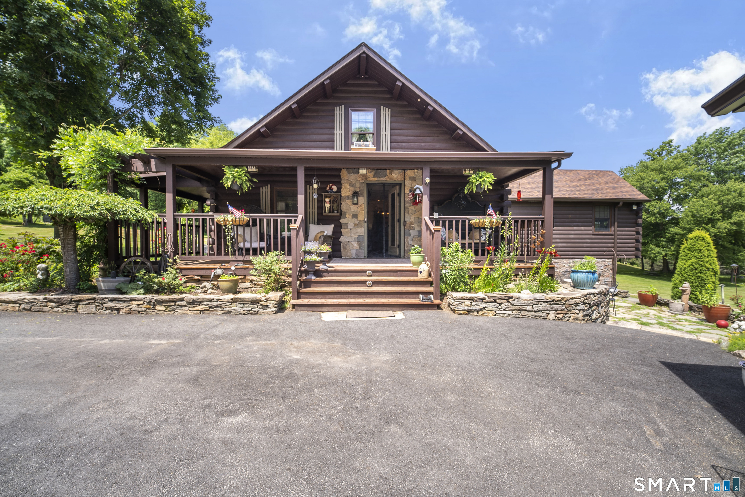Welcome to your own private country retreat! This exceptional log home offers the perfect blend of rustic charm and modern updates, nestled on a picturesque property designed for those seeking peace, privacy, and room to roam.The heart of the home is the brand-new great room addition, featuring soaring cathedral ceilings, abundant natural light, and direct access to a spacious deck overlooking the beautifully landscaped grounds. The open-concept layout flows seamlessly into the updated kitchen, complete with granite countertops, a center island, custom cabinetry, and stainless steel appliances-ideal for entertaining family and friends. A stunning floor-to-ceiling stone fireplace, exposed beams, and warm wood ceilings create an inviting atmosphere throughout.The spacious primary suite offers its own private retreat with sliders leading directly to the deck, allowing you to enjoy your morning coffee while taking in the peaceful surroundings.Outside, this remarkable property truly shines. Enjoy your own private 19-foot-deep pond, perfect for relaxing, fishing, or simply enjoying nature. The impressive two-story barn provides endless possibilities for storage, workshop space, hobbies, equipment, or livestock, while the charming chicken coop is ready for your backyard flock.Grow & sell your own veggies with greenhouse in place for gardening, recreation, or creating your own hobby farm.A rare opportunity to own a truly special New England log home.
