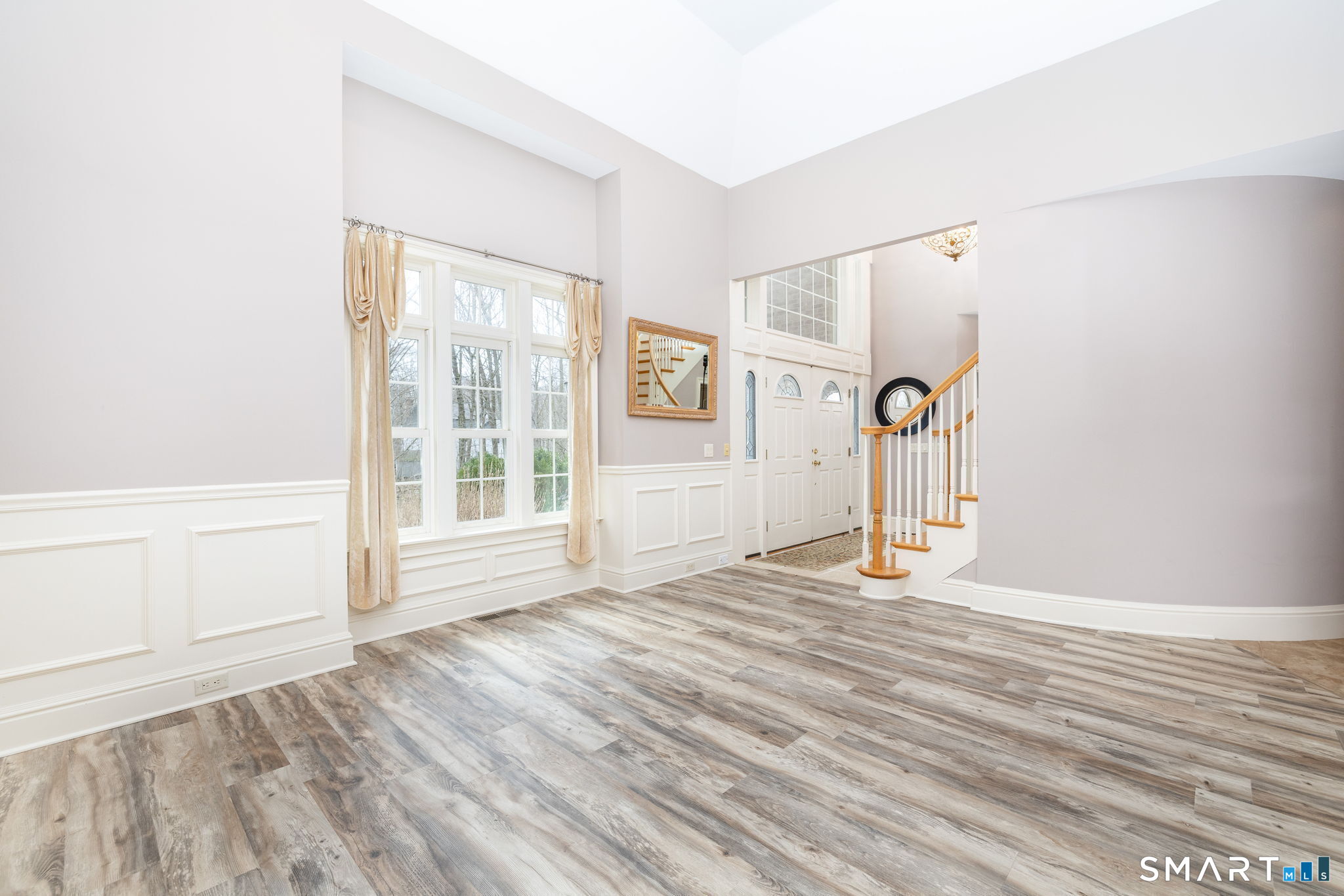 The living room open to the foyer and featuring the rounded wall leading to the dining room.