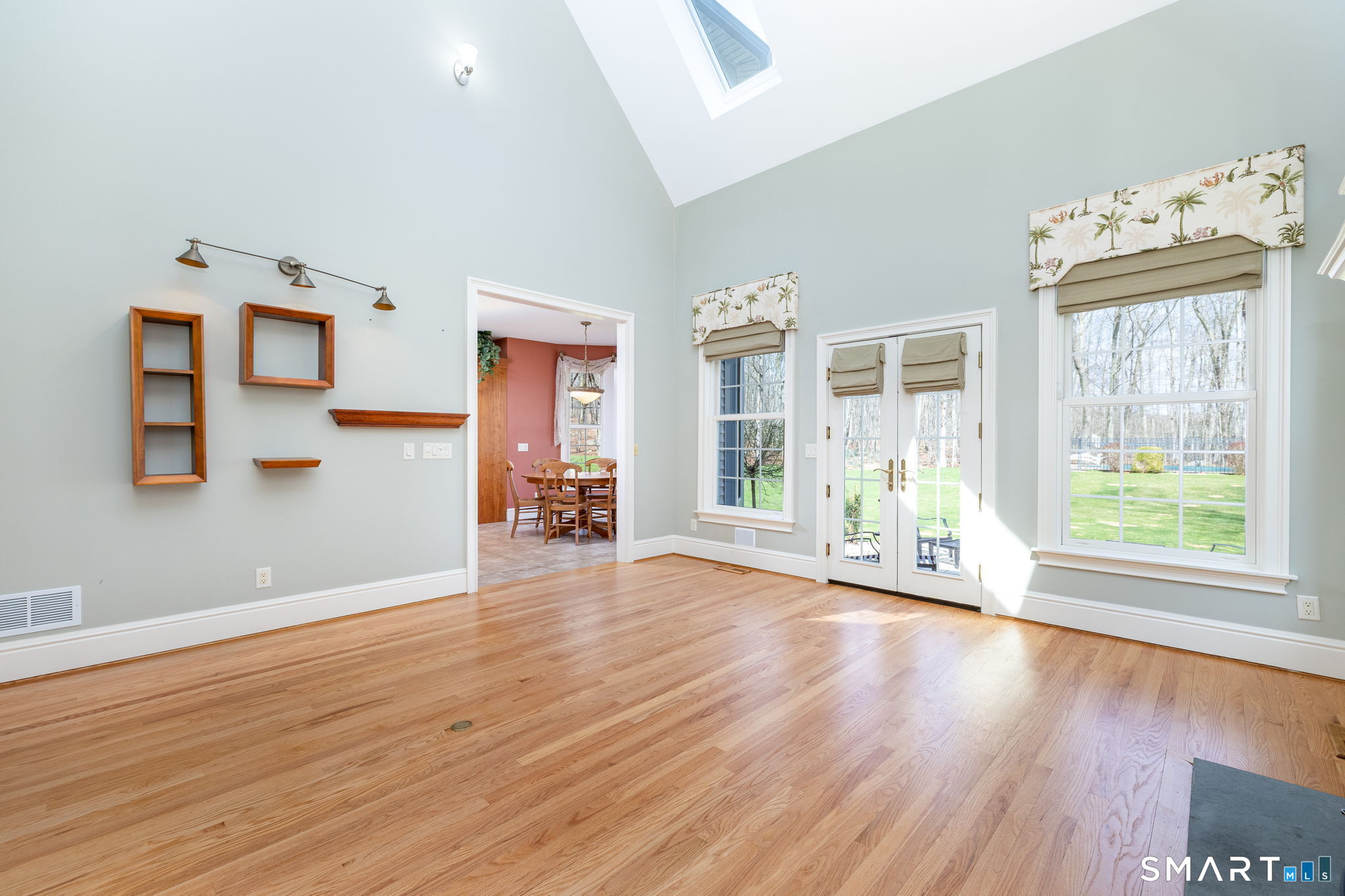The family room is open to the kitchen area and the media room. French doors lead down granite steps to the patio installed in 2024.