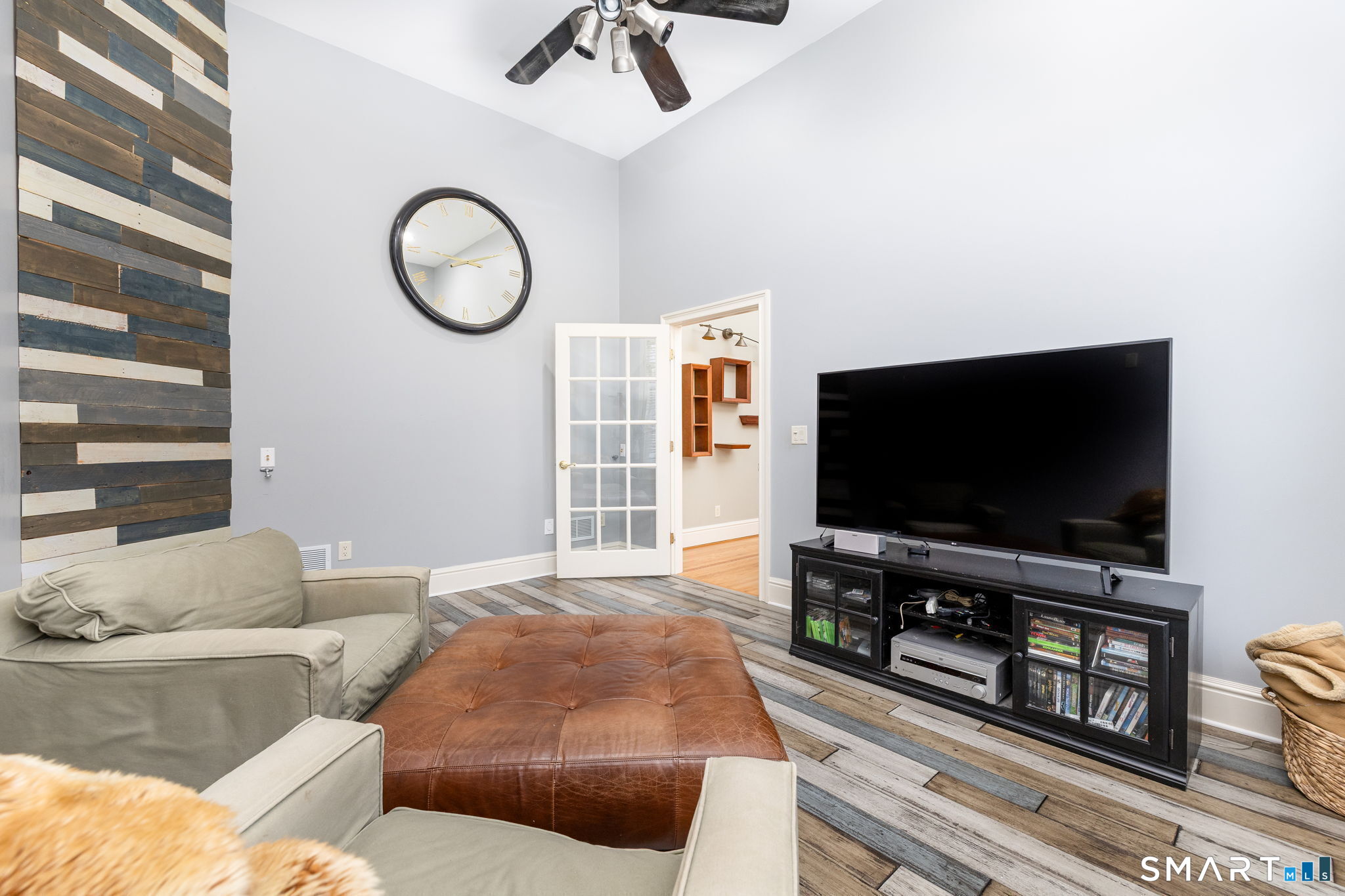The 15'10" x 11'9" media room is fully wired for surround sound. Oversized windows are adorned with custom plantation shutters, and the room also features a ceiling fan, and accent wall.