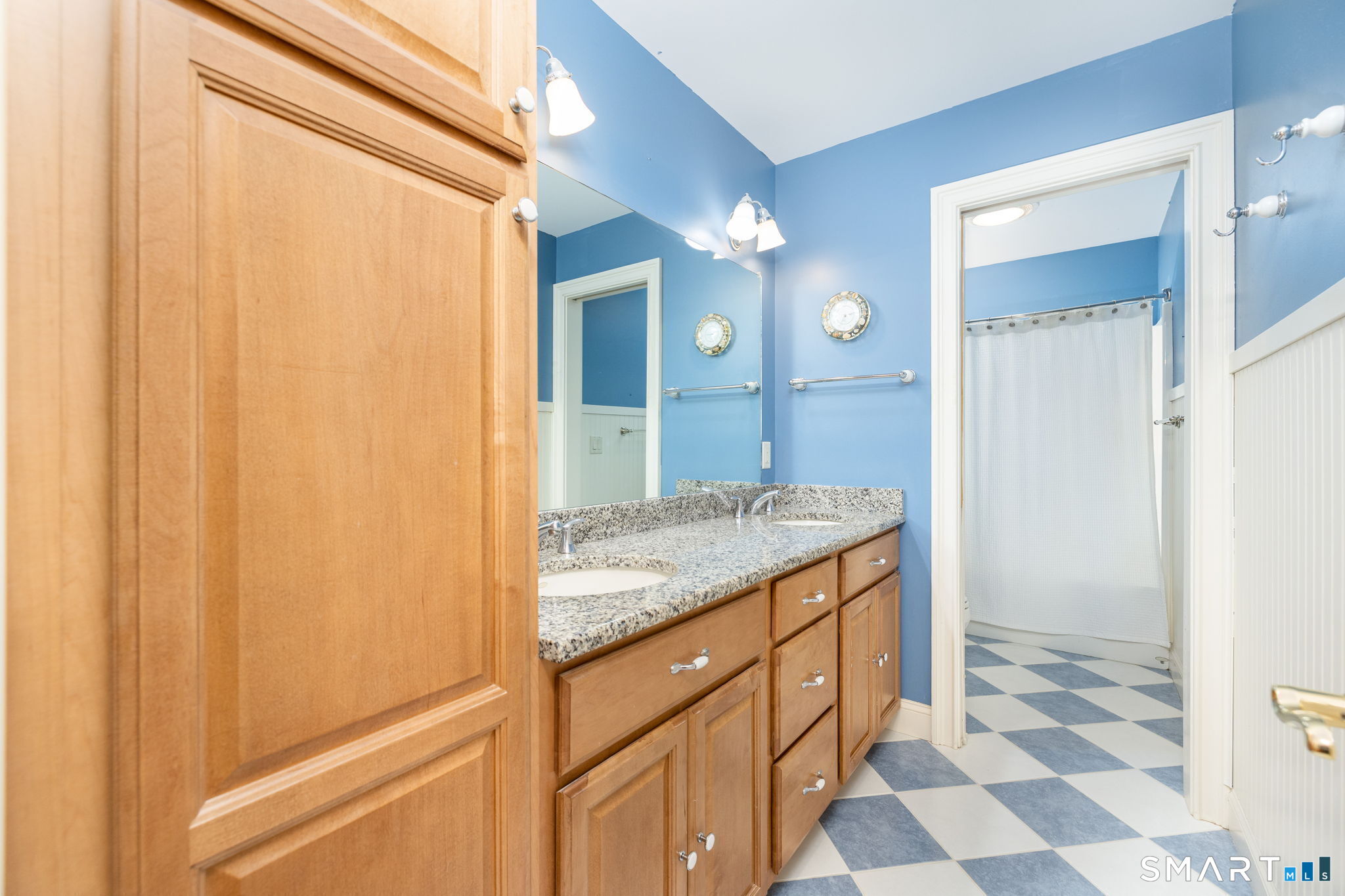 This is the upstairs hall full bathroom services bedrooms 3 & 4, with double sinks, a tub/shower, and lots & lots of storage!