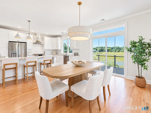 The dining area enjoys the marsh as its backdrop, framed by the kitchen window and sliding doors leading to the Trex deck.