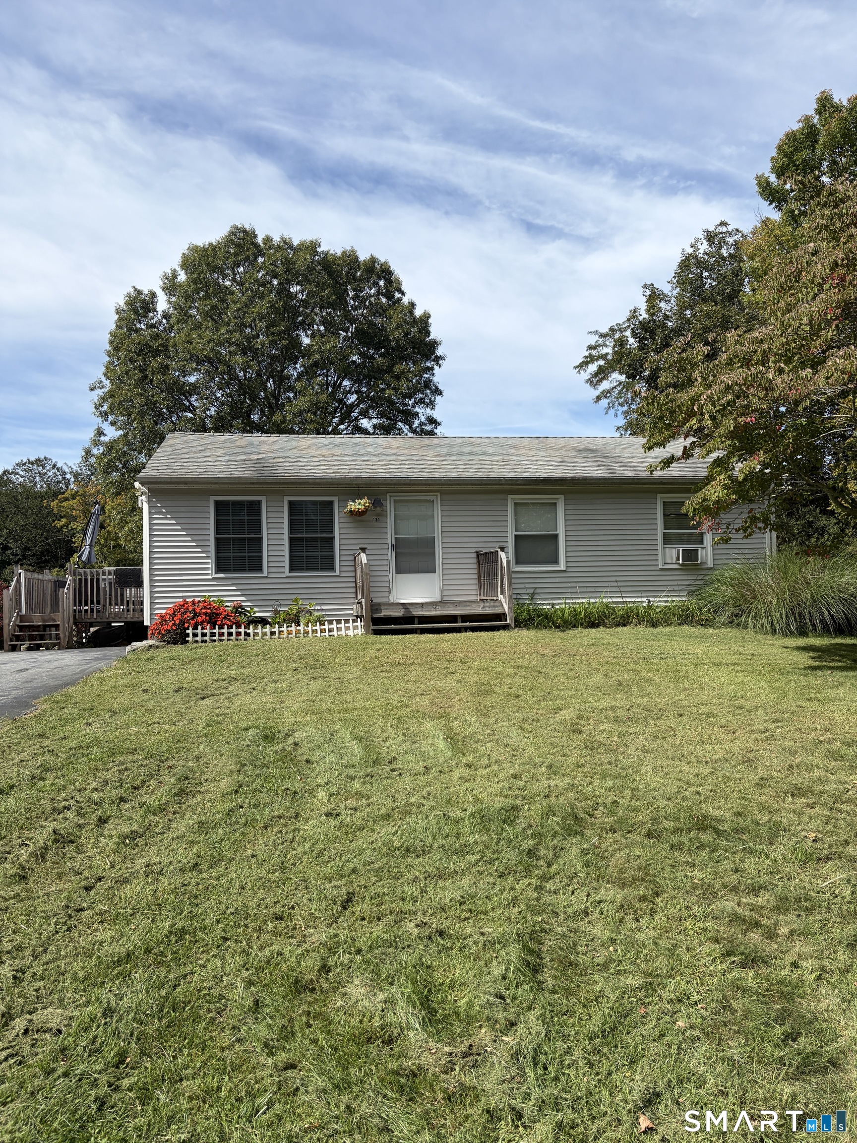 Welcome to 131 Ross Hill Road, a charming and recently refreshed ranch offering comfortable one-level living on more than an acre of beautiful, flat, cleared land. Built in 1982, this 960-square-foot home features 2 bedrooms, 1 full bath, an open-concept living area, and a functional layout with all primary living spaces conveniently located on one floor. Step inside to a bright, fresh interior that has been newly painted throughout. The recently updated kitchen offers a clean, modern look and flows naturally into the open living area, creating an inviting space for everyday living and entertaining. The updated bathroom complements the home with contemporary finishes and a fresh, modern feel.  The spacious primary bedroom was previously configured as two separate bedrooms and has been converted into one generously sized bedroom with abundant closet space. The unfinished basement offers excellent potential for additional living, recreation, hobby, or storage space.  Outside, enjoy more than an acre of level, cleared property, as well as a side deck that provides a convenient outdoor space for grilling, dining, or unwinding. A major bonus is the large detached garage. Car enthusiasts, mechanics, and hobbyists will especially appreciate the existing car lift, which can remain for a buyer who wants it or be removed if preferred. This home offers a wonderful combination of move-in-ready comfort and future possibilities. Come and see all this inviting Connecticut ranch has to o