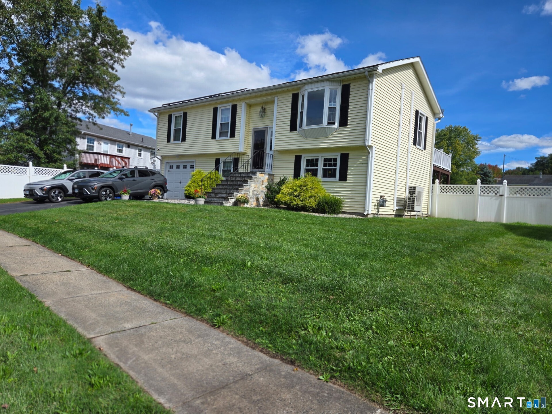 Welcome to this lovely 3-bedroom, 1-bath raised ranch in a peaceful East Hartford neighborhood near the Chipper Drive Trail. Bright and cheerful, this well-cared-for home has a warm, welcoming feel from the moment you walk in. The main level features a light-filled living area, three bedrooms, and a full bath. Thermopane windows add energy efficiency, while five mini-splits, installed in 2020, provide heating and cooling throughout the home. Solar panels (PPA) provide an opportunity for meaningful savings on electricity. A one-car attached garage adds everyday convenience. The lower level is largely finished and includes an additional half bath, along with a versatile room that could serve as a home office, guest area, hobby room, or possible fourth sleeping area. The walk-out leads directly to the backyard and gives this level a wonderful sense of openness and flexibility. Outside, a large deck overlooks the beautifully fenced backyard, creating an ideal setting for summer gatherings, morning coffee, gardening, or simply enjoying the outdoors. The Chipper Drive Trail is nearby, offering an easy opportunity to get outside for a walk or enjoy some fresh air. Restaurants, shopping, theaters, major highways, and convenient routes toward both New York and Boston are also close by. Schedule your private showing today.