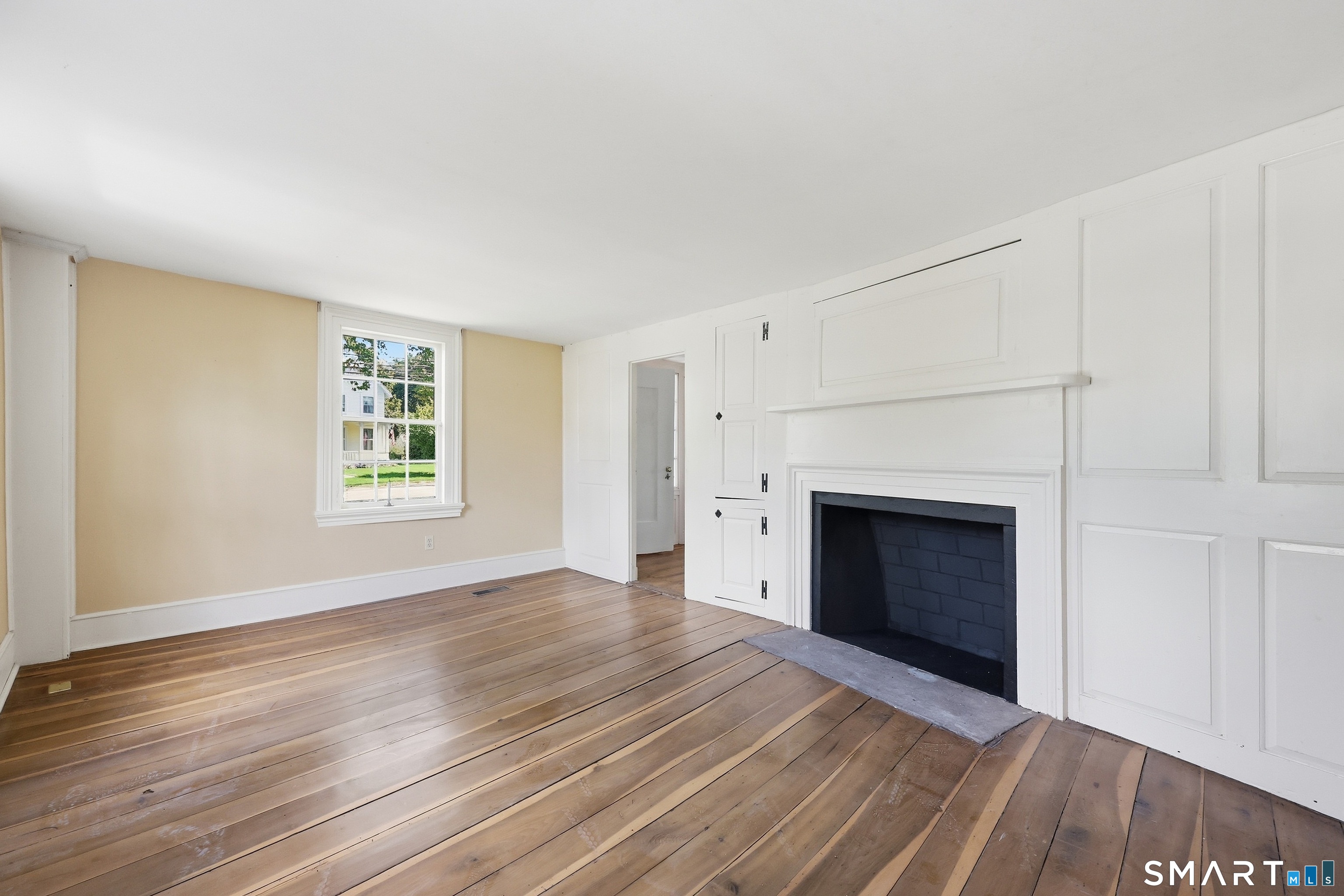 Front facing living room with fireplace & original moulding detail.