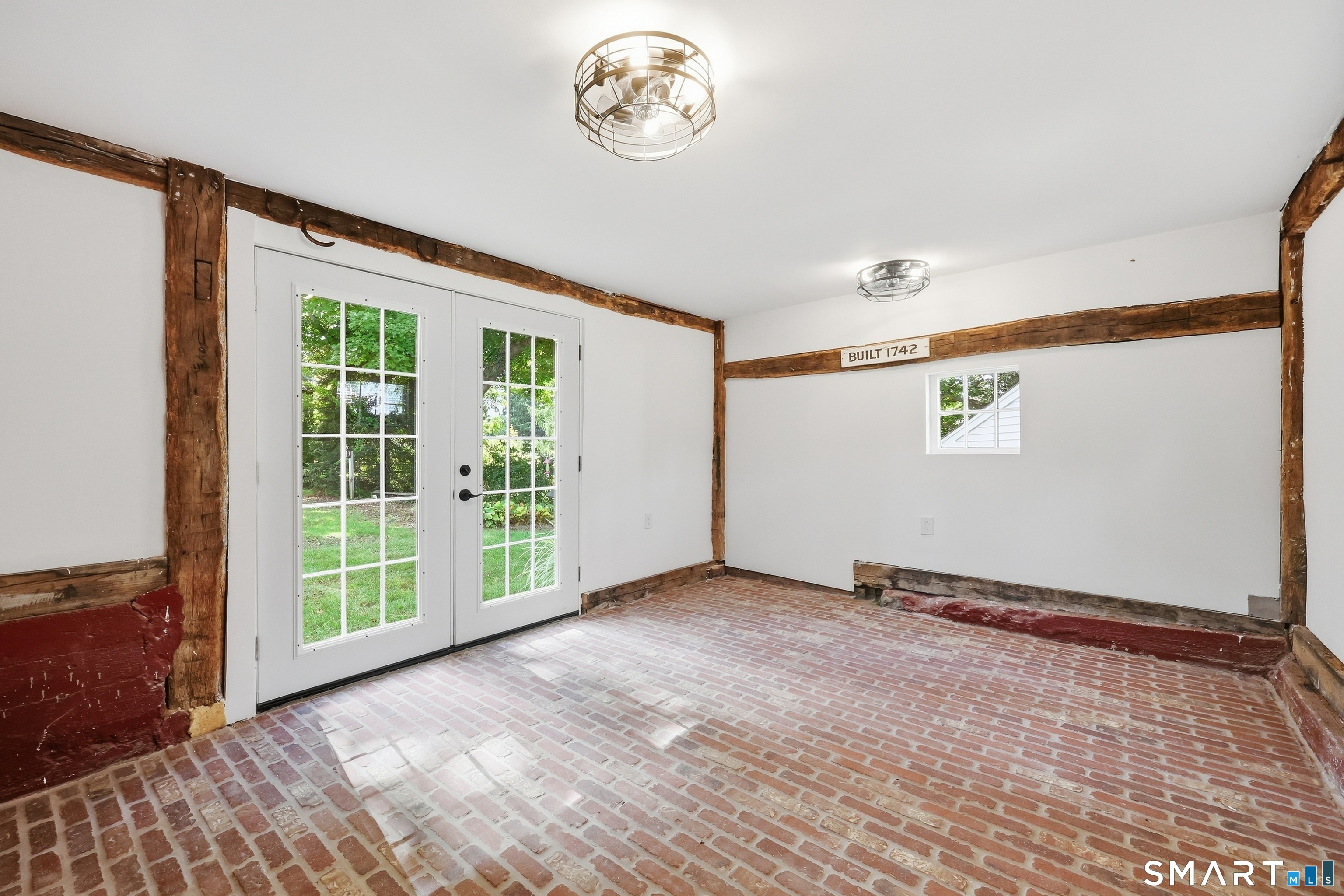 NEWLY RENOVATED sunroom with gorgeous brick floor & french doors leading out to patio.