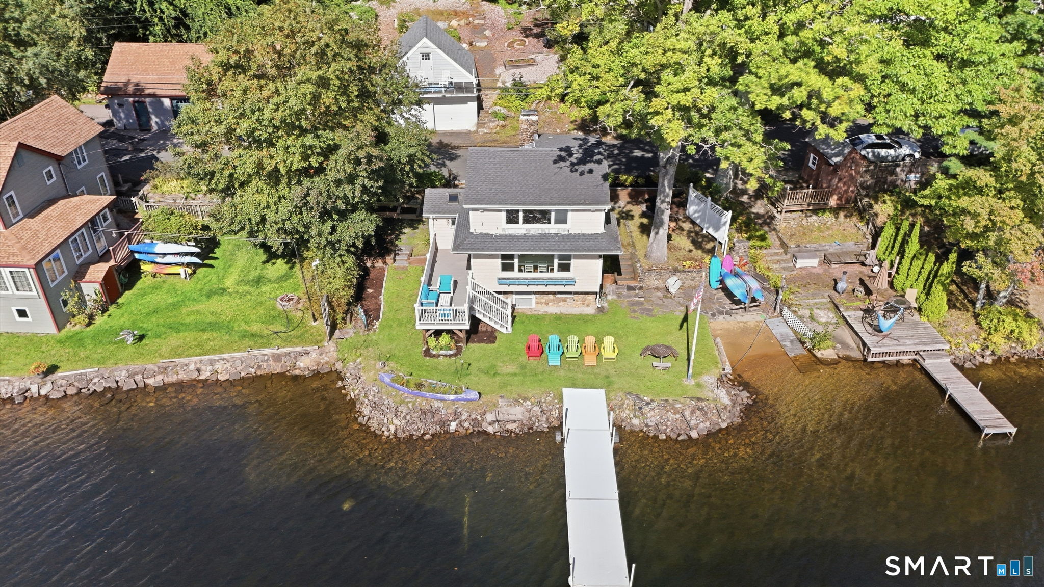 A true Crystal Lake retreat! This distinctive waterfront Colonial is ideally positioned along the west shore of Crystal Lake, offering beautiful lake views and the opportunity to enjoy the best of four-season lake living. Inside, charming post-and-beam construction, gleaming hardwood floors, abundant natural light, and a striking fieldstone fireplace create a warm New England atmosphere. The open floor plan is designed to maximize the views, while the upstairs bedrooms take full advantage of the peaceful waterfront setting. Step outside to enjoy your private dock/boat slip, lake-access beach area, expansive lawn areas and a waterfront trex deck-perfect for morning coffee, afternoons on the water and spectacular sunsets. A detached two-car garage with new roof and an added storage space above adds a valuable area to stow outdoor equipment, kayaks and more. Newer updates include Renewal by Anderson windows, trex deck, sump pump, oil tank, water heater, well pump, and landscaped garden beds. Whether you're looking for a year-round residence, weekend getaway or special place to create generations of lake memories, 149 W. Shore Rd. offers a rare opportunity to experience Crystal Lake living at its best.
