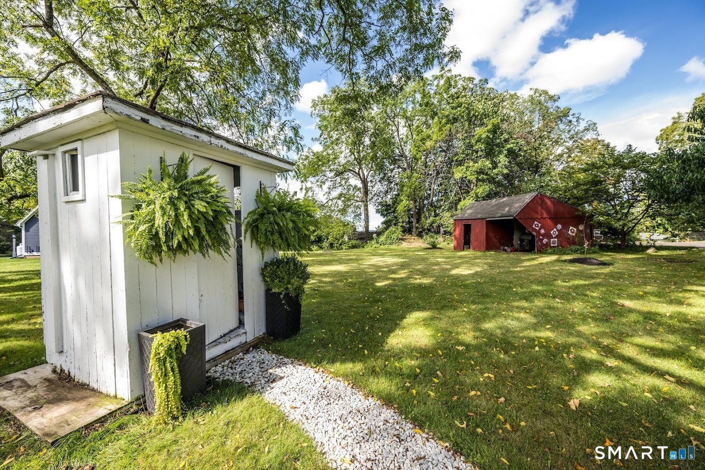 Spacious backyard with mature trees, open lawn and additional outbuilding, offering plenty of room to enjoy the outdoors.