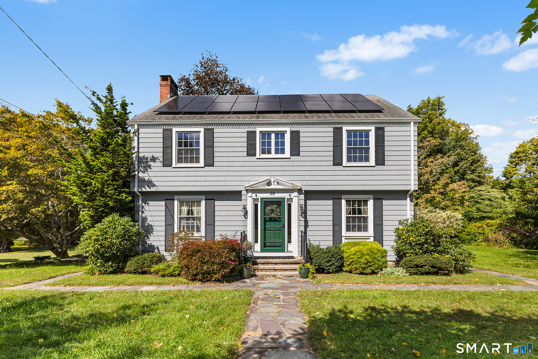 Welcome home to this impeccably maintained village colonial that brilliantly marries exquisite vintage detailing with a timeless floorplan perfectly suited to modern living. Fine millwork, handsome built-ins, and glorious natural light beckon you in to explore a residence that truly has a soul! The front facing living room, anchored by a wood-burning FP, is the perfect place to unwind. A grandly-scaled dining room flows seamlessly into the cabinet-packed kitchen complete with a custom tiled backsplash, S/S appliances, large pantry, & granite peninsula w bar seating. A cheery breakfast nook leads to a fabulous enclosed porch - a cozy sanctuary overlooking a sprawling flat yard with a dining patio & hot-tub. The great room is the crown jewel of this entertainer's dream layout. Soaring tongue-and-groove ceilings, a majestic Palladian window, and an epic wall of custom bookshelves set the stage in this dramatic space crafted for large-scale hosting and effortless relaxation alike. 1/2 bath rounds out main level. Upstairs, the spacious primary bedroom features two generous walk-in closets accompanied by two additional well-appointed bedrooms and a chic full bath. Walk-up attic and large basement offer plenty of storage. 1 car attached garage. There is a rare, effortless calm built into every square foot. Whether you're curled up inside or the fall breeze is hitting just right on the porch, it isn't just a collection of rooms or a place to live - it's a true haven, it's HOME!