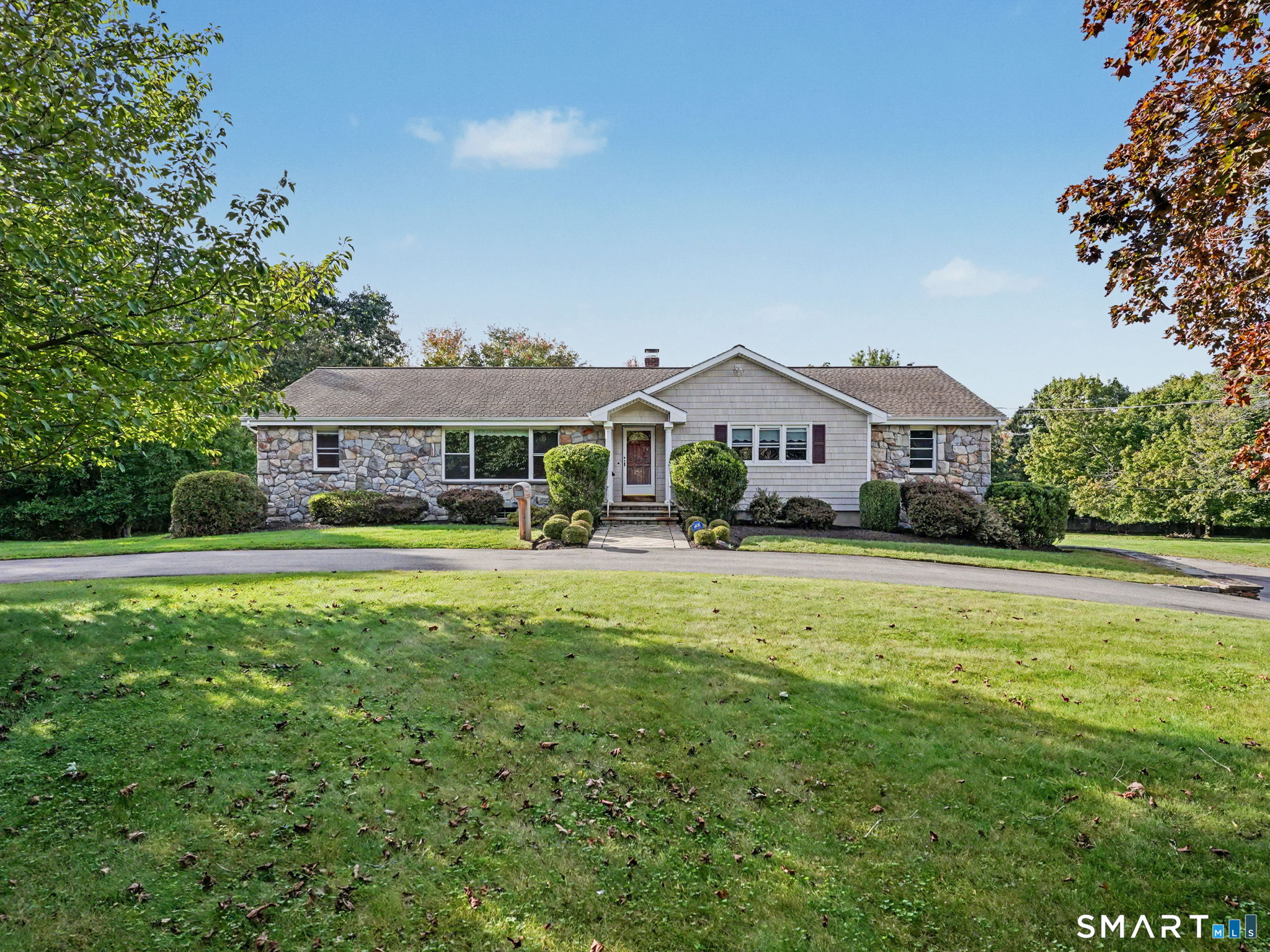 Welcome to 7 Clearview Drive, a spacious ranch set on 2.14 incredible, level acres in Woodbridge. A recently paved circular driveway, cedar shake-style vinyl siding and stone accents make a great first impression. Inside, 2,294 square feet of single-level living starts with a living room featuring a large picture window overlooking the front lawn, open to the dining room. The eat-in kitchen offers plenty of cabinetry, a peninsula and main-level laundry, and flows into the family room with a fireplace and slider to the deck. Just off the kitchen, the enclosed sunroom is a bright space to enjoy all year round. The primary bedroom includes a walk-in closet and private bath, and two additional bedrooms share a full hall bath. Hardwood floors are under the carpeting, ready to be uncovered. Outside is where this property really shines. The deck looks out over a huge, level backyard framed by mature trees, with endless room to garden, entertain or simply spread out. The full basement offers abundant storage and room to expand, plus a 2-car garage. Additional storage: walk-up attic & shed below the sun room. A Generac whole-house standby generator adds peace of mind, along with central air. All in the Amity Regional School District, just minutes to Route 15, Yale, Yale New Haven Hospital and downtown New Haven. A well-cared-for home with great bones, ready for its next owner to make it their own. Home to be sold 'as-is'.