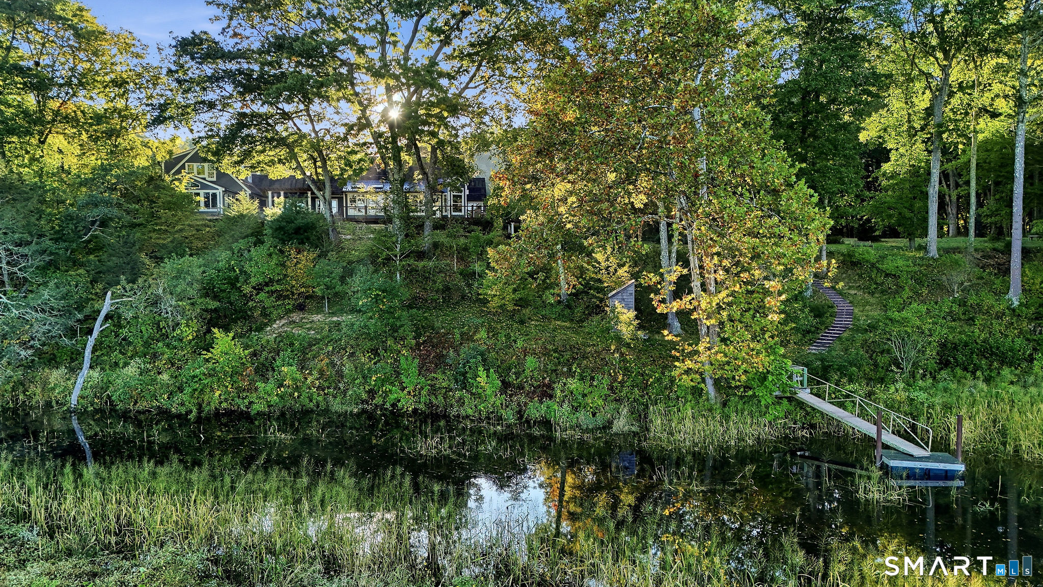 A pebble and stone staircase and permitted dock afford access to explore the cove and nearby CT River
