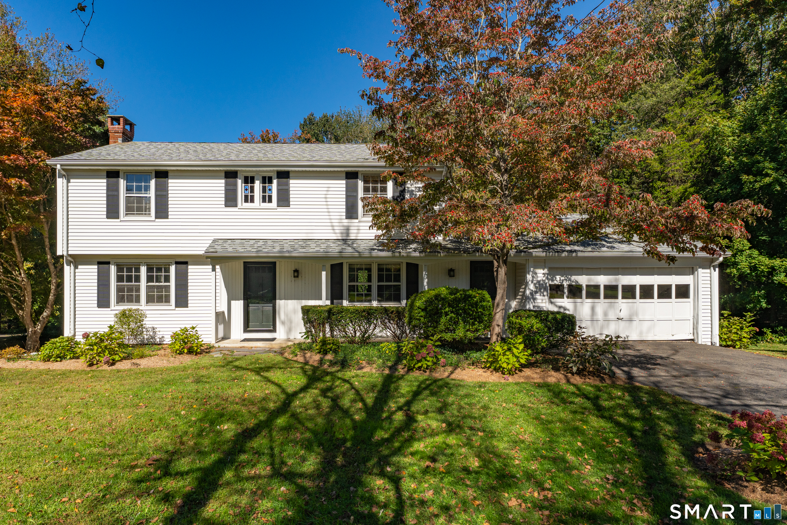 Nestled on a picturesque stretch of Madison's desirable shoreline community, this exceptional property offers the perfect blend of New England charm, privacy, and convenience. Set on a beautifully maintained lot, 14 Bower Road provides an inviting setting for year-round living or a relaxing coastal retreat. Thoughtfully designed living spaces are filled with natural light, creating a warm and welcoming atmosphere throughout.  The home features spacious gathering areas, a well-appointed kitchen, comfortable bedrooms, and seamless indoor-outdoor living ideal for entertaining family and friends. Outdoor spaces offer room to relax, garden, or simply enjoy the tranquility of the surrounding landscape. Ideally located just minutes from Madison's vibrant town center, beaches, boutiques, restaurants, and commuter routes, this property combines a peaceful residential setting with easy access to everything the Connecticut shoreline has to offer.   A two-car attached garage and full walk-out basement provide excellent storage, workshop space, or future finishing potential. The private backyard offers plenty of room for entertaining,
