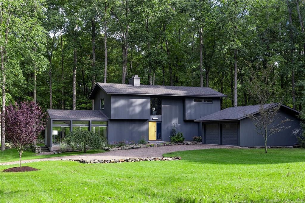 A Rare Mid-Century Modern in Woodbury, CT. Resting on nearly 7 private acres, the newly reimagined home features elegant stone-walled gardens as well as a mature woodland setting - specimen trees of weeping spruce, Japanese pine, and plum have been freshly planted. At just under 2, 000 sq ft, the house is graciously scaled. The first floor offers an open living plan with liv/din room and kitchen area, sunken den with fieldstone floor and wood-burning fireplace, and a large four-season solarium. Glass doors throughout create a seamless transition to the exterior where you'll find a bluestone patio just off the dining area. The kitchen appointed with new Bosch appliances is anchored by a luxurious waterfall island of Statuario Venato quartz. A mudroom with laundry and half bath links the main house to the garage. The 2nd floor boasts a generously sized primary bedroom with gas fireplace and generous closets. The ensuite bath has a large walk-in shower, floating walnut shelf vanity with vessel sink, and imported porcelain tile. The 2nd and 3rd bedrooms are of equal size and share a new full bath with a tub/shower combo. A thorough remodel with uncompromising attention to detail by an award winning NYC interior designer to bring this 1966 home into the 21st Century, including new kitchen, baths, interior and exterior lighting, HVAC, generator and septic. 90 from NYC and minutes from the shops and restaurants of historical Woodbury, this is an opportunity not to be missed.