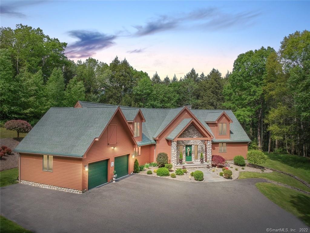 As you pass the gated entrance and tall trees that line the drive approaching this private country getaway, you'll think you're on vacation. Whether entertaining guests or just relaxing, the 1000 sq ft Great Room with 16' Cathedral Ceiling and soaring riverstone fireplace make every day special. Sunlight streams through the arched windows facing the back of the home with a 50' deck that leads to the outstanding heated gunite pool. The first floor primary bedroom suite with fireplace and sliders to the deck adjoins a full bath with heated floor, jetted tub & walk-in shower. Adjoining the Great Room is the spacious kitchen with granite counter, double-oven, heated tile floor and stainless steel appliances. A full bath & separate laundry room are close by and lead to the attached two-car garage. There's plenty of room for guests in the three bedrooms with full bath on the upper level. A finished walk-out lower level with fireplace adds 540 sq ft to the home & is adjacent to an unfinished space with wine closet & mechanicals including a hydro-air heating system. Car enthusiasts & hobbyists will appreciate the detached 24 x 40 garage/barn with 12' insulated doors & 2x6 construction. The private 10+ acre parcel includes a large, level lawn with playscape and a path leading through the forest to 1000' of river frontage for fishing or just getting close to nature. Private and pristine, this stay-cation paradise is just a few minutes from shopping & Woodbury's acclaimed restaurants.