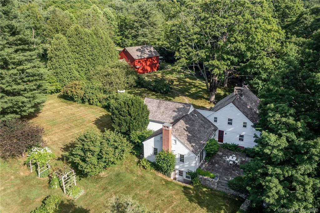 The historic homestead of Andrew Tuttle sits on 26 acres, just outside of the town center. The home has been lovingly preserved, restored and updated. Ca 1780, the house boasts it's original antique features including horizontal and vertical board paneling, wide board wood floors, exposed beams, doors, built-ins and hardware. There are 3 original fireplaces, one with a bee-hive oven. A Charming corner cupboard adorns both the formal dining room and family room. The charming living room is great for entertaining and includes built-in bookshelves and fireplace. The first level primary bedroom offers french doors onto a stone terrace and an updated full bath. There are three additional bedrooms with a walk in cedar closet for great storage and an office/music room on the second floor, along with an update bath on the upper level. Picturesque grounds include a rolling lush lawn, stone terrace, stone walls, mature perennial gardens, fruit trees, flowering bushes, grape vines. The Studio Barn has is ideal for an artist studio or woodworker with insulation and flooring added to the studio space or can easily be reconverted to the original space as a garage. The Summer House is a fabulous dining area or bunkhouse which sits out just past the gardens. The Property includes a parcel across the street. Conservation easement to maintain its history and beauty. All this just 90 minutes from NYC, minutes from great dining, shopping and hiking in Award Winning Historical Woodbury!