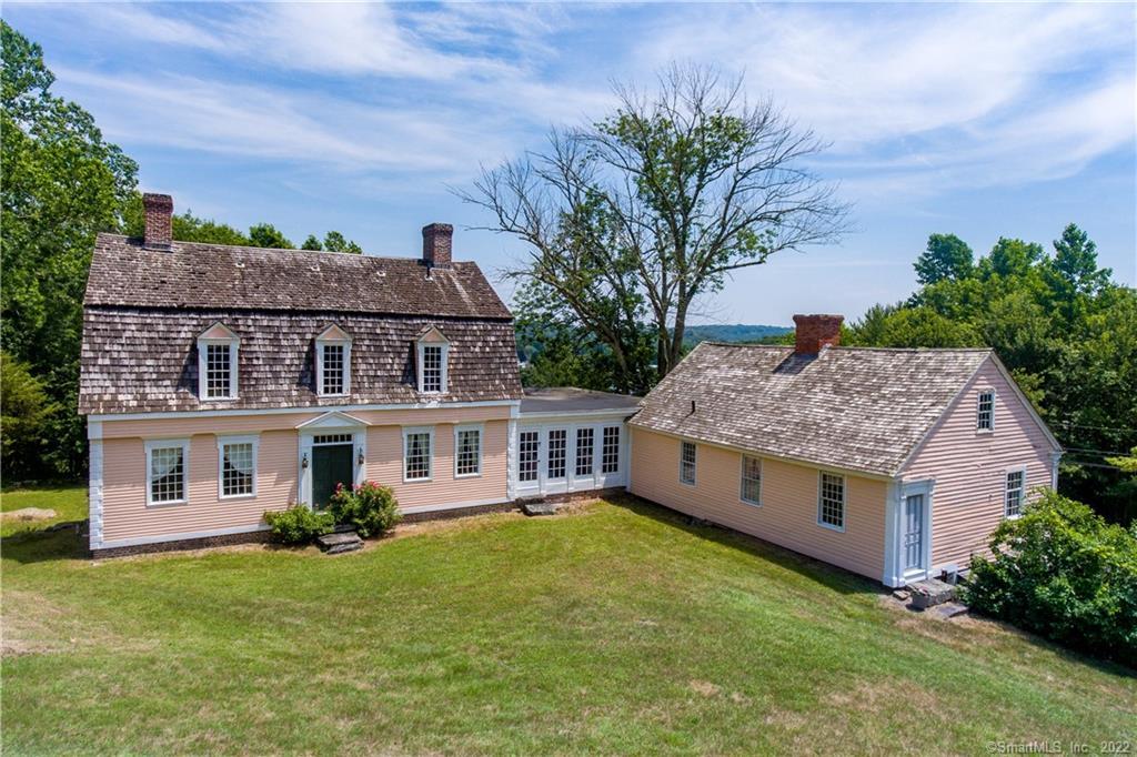 This remarkable property represents an eclectic blend of 2 historic embankment homes on a bucolic 6.8 acre parcel, high on a hill above Hamburg Cove of the lower CT River. In 1989 the John Mansfield house from Wallingford was moved to 83 Joshuatown Rd in Lyme, where it was reconstructed as a wing to the original existing circa 1760 antique colonial home. The two homes were joined by a constructed common kitchen area with a two story ceiling and arched windows providing wonderful views down the hillside toward Hamburg Cove. The French Doors lead to the garden with fountain and garden house. Architectural artifacts are creatively used throughout the home. The property offers 5 bedrooms, 4 full baths and 2 half baths. The lower level of the Mansfield house connects to the kitchen and contains the tavern room, a home office and an exercise room. Ascending the staircase from the kitchen brings you to a landing with the first floor of the Mansfield house and the second floor of the original 1760's home. This second level of the original home offers two bedrooms, with views of the cove and two full baths. The Mansfield wing brings you to the music room, library, main parlor and center hall. The upper level has 3 bedrooms and two full baths, perfect private guest accommodations. Not to be missed is the 56' x 44' post and beam barn with garage for six. Enjoy the convenience of being halfway between New York and Boston while living in the historic town of Lyme, CT with marinas.