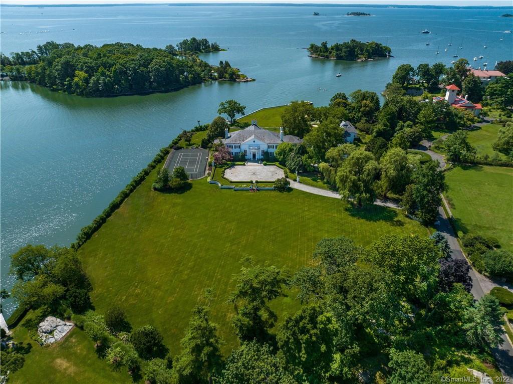 Proudly presenting a unique opportunity to acquire one of the most significant waterfront estates in Greenwich history. 21 Vista boasts the rarity of 5.8+ acres and 750+ ft of shoreline frontage with breathtaking water views from sunrise to sunset. Located in the Indian Harbor Association where a guarded gate house allows heightened privacy and security, yet the convenience of downtown Greenwich is just moments away. Spectacular curb appeal with stunning mature landscaping, flat expansive front and rear yards, tennis court, deep water dock, and a magnificently sited pool provide endless enjoyment and entertaining possibilities. The exquisite bones of the original house built in 1939 are on full display throughout; from the soaring entry, to the recently refreshed grandiose formal areas and family spaces to the bedrooms with views of water and sky, sprawling guest suites and generous staff accommodations all offer boundless options to create a modern living plan, or a multi-generational compound. A substantial addition built in 2000 features a decadent indoor lap pool, a great room with beamed ceiling in excess of 20ft, and comfortable guest areas with private entries. Create and fulfill all your waterfront living dreams at the tip of the peninsula, end of the cul de sac, monumental 21 Vista Drive.