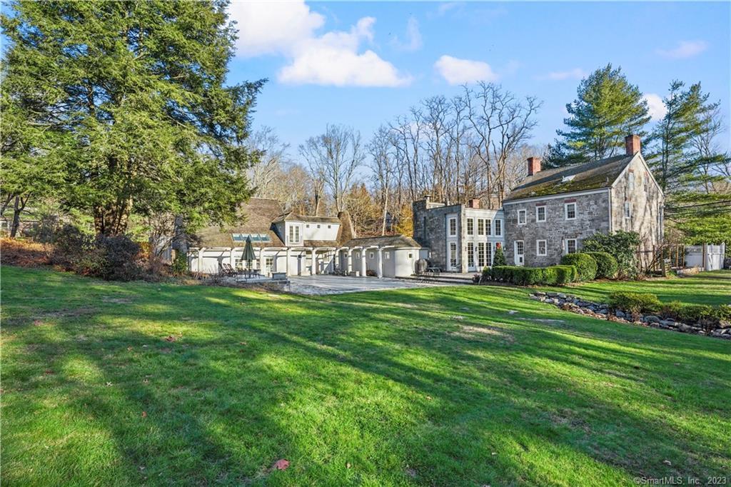 You don't have to choose between modern comfort and historical charm. Anchored on the original 1721 granite block house, this home is situated on two enclosed acres of beautifully maintained grounds in back country Stamford on the Greenwich line features a unique in-ground pool surrounded by a fieldstone terrace. At the heart of the home is a two-story cathedral ceiling, open plan great room and a state-of-the-art kitchen featuring a custom 8-foot wide fireplace, granite countertops, Wolf stove, double ovens and a spacious pantry. Floor-to-ceiling windows with French doors open to the terrace and pool. Off of the kitchen is the dining room which features a fireplace, beautiful, stenciled floors and exposed wood beams. The living room and library, each with its own working fireplace and the original wide floorboards, are also on the first floor.On the second floor are two additional bedrooms, a full bath, laundry, and a grand primary suite. The primary suite boasts wooden beams, en-suite bath, and dressing area complete with a gigantic two-level, walk-in closet. The third floor completes the antique part of the house with a bedroom, study and full bath.The modern portion of the house features two additional bedrooms, two full baths, and a spacious living room with a kitchenette that looks out through two double French Doors onto the pool.