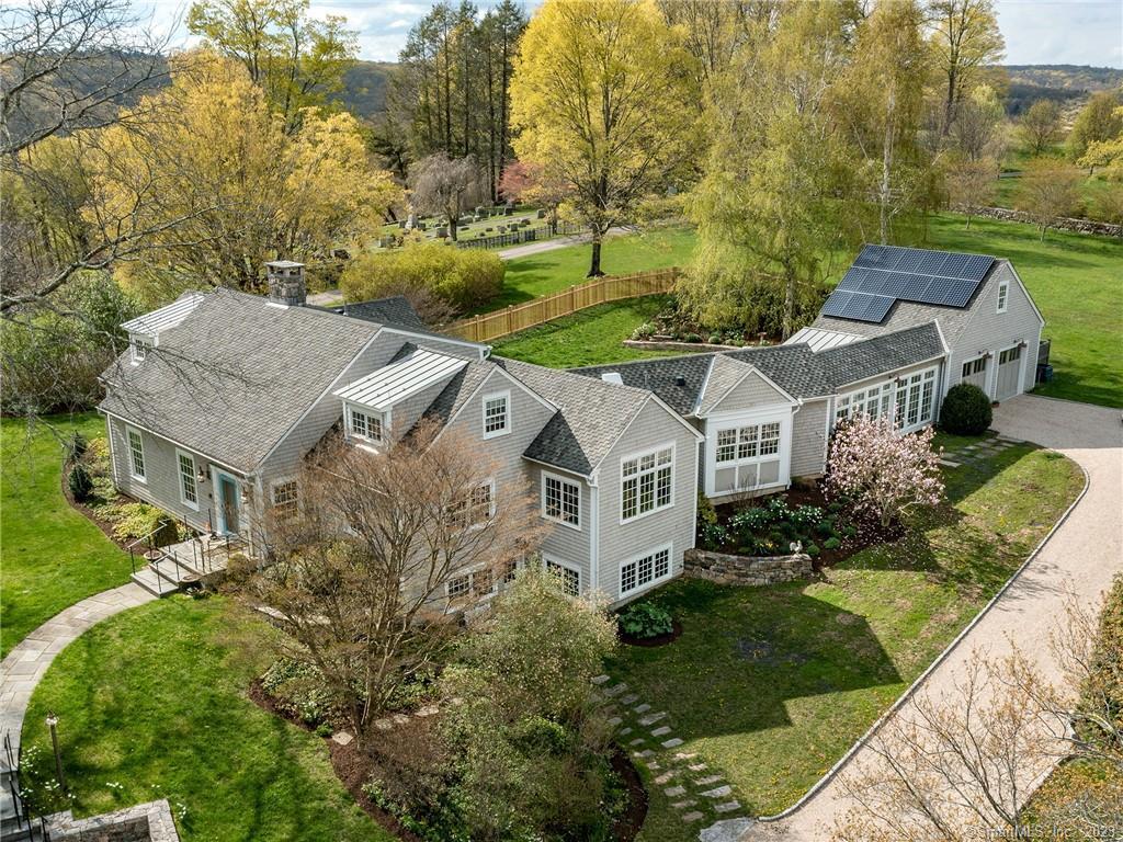 This charming Parsonage Lane home sits atop the prestigious Washington Green with mature gardens & spacious lawns for play. Walk directly from the house to The Washington Club, The Mayflower Inn, The PO Cafe & into 1000+ acres of Steep Rock Land Trust. The home has been fully renovated to perfection, adding geothermal heat, solar array, a top of the line chef's kitchen. The office is just off the kitchen for easy access and can double as a breakfast nook. The primary bedroom is on the main level & walks out to the terrace and pool. The additional two bedroom suites are located on the 2nd floor & each boasts its own private sitting room. Currently they share a bath but it would be easy to add another ensuite. There are multiple living spaces incl: a sun room w/ French doors overlooking the pool, family room/media room, formal living room w/ fireplace, & formal dining room. The lower level offers a walk-out game room/gym/potting station/workshop with extensive built-in storage. Additional amenities incl: sound system, wide board white oak floors, Marvin windows, 40 year roof, whole house generator. Gorgeously landscaped grounds - complete with Gunite heated pool, stone terraces & specimen trees. Only 2 minutes into Washington Depot for chic shoppes & markets. 90 miles to NYC. Enjoy privileges at the Washington Town Beach on Lake Waramaug.