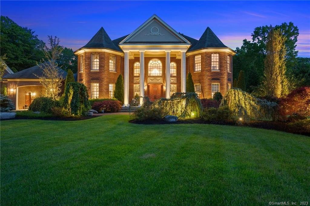 Old world charm abounds in this neoclassical home suffused with European elegance set on a quiet, wooded cul-de-sac in E. Greenwich. Soaring Ionic columns support a portico emblazoned with a Greek crest and flanked by a pair of distinctive Victorian turrets, providing a magnificent welcome as the eight-foot mahogany front doors open to reveal sweeping staircases curving up to a second-floor balcony. Cross a foyer lit by sparkling chandeliers and inlaid with an intricate mosaic floor to take in views of the two acres of sylvan grounds. The kitchen is a gastronome's delight, with Sub Zero & Wolf appliances, a vast center island with built-in prep sink & food warmer, & a spacious attached butler pantry & laundry room. Fine details in this durably constructed contractor's home capture the eye everywhere, from exquisite woodworking employed for wainscoting & crown & ceiling moldings, to Brazilian cherry floors inlaid with walnut. Twenty-foot ceilings, arched windows and French doors fill the living room with light. The room is warmed by one of three gas fireplaces in the home; another adds coziness to the spacious first-floor master suite, highlighted by a double-sized jetted tub set into a private turreted nook. All three upstairs bedrooms have en-suite baths, plus a balcony space that can serve as a office or den. A hidden four-car garage faces a private cobbled courtyard that's perfect for parties in a setting reminiscent of a grand country estate. GPS1607 MIDDLE RD E.GREENWICH