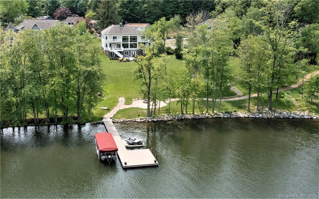 Stunning custom-built lakefront with 275 feet of frontage with expansive property and privacy. This well-designed home has an open concept, soaring ceilings, & walls of windows with beautiful lake views. Lake views from the minute you enter! The main level has 9' ceilings and a great room has walls of windows with gorgeous lake views & indoor firepit with overhead venting. The large dining room has a trayed ceiling & is perfect for large gatherings. The custom kitchen granite counters and high-end stainless appliances & a breakfast area. A lakeside octagon media room & a home office complete this level. The upper level has an oversized owner's suite with vaulted ceilings, ample closets & a balcony overlooking the lakefront. The luxurious owner’s bath has a large shower area with glass surround & soaking time with lake views. Enjoy the lakeside bedroom with a balcony with lake views & a Jack and Jill bath &large bedroom loft above with 4 beds for guests It’s all about entertaining in the 1300 SF lake-level great room with sliders to the expansive patio with views of Candlewood Lake. The home has a golf cart path to the lakefront & firepit area. There is a deep-water dock and jet-ski ports. Located in a no-wake area this home is perfectly designed for lake living at its very best! Minutes to all conveniences of shopping and commuter routes. The home has forced Hydro-air heat and central air conditioning. There is a two-car garage and plenty of parking. A rare find!