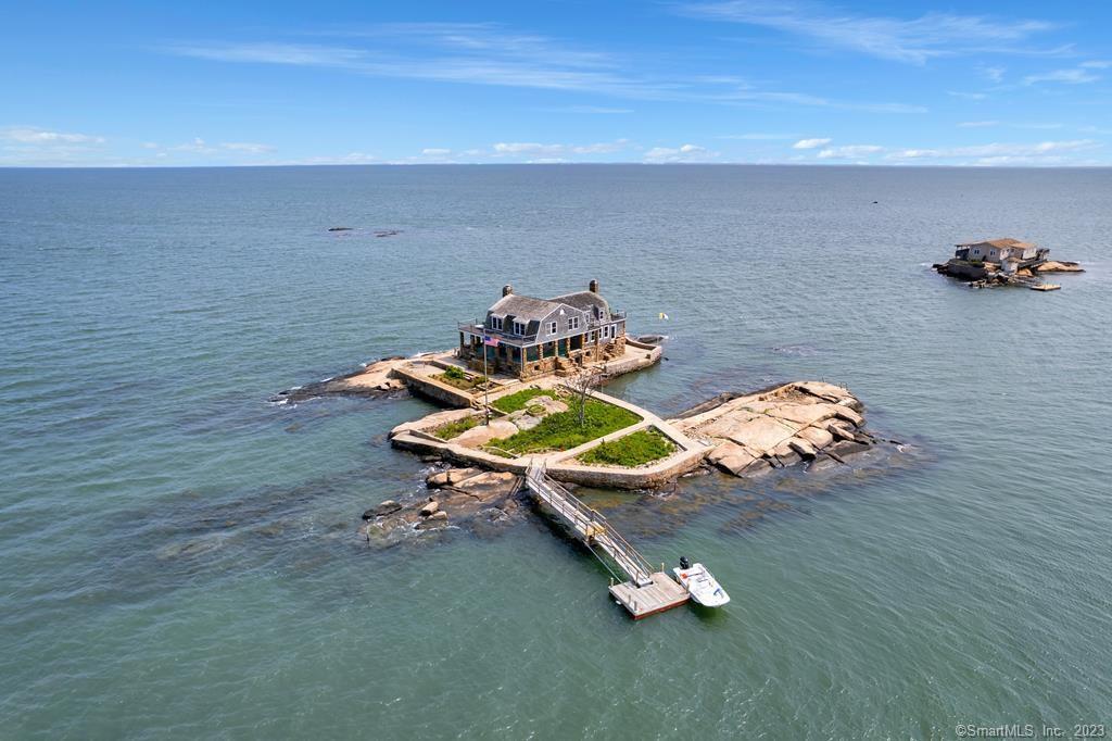 Welcome to Gray Rock, your own private island! Located in the Thimble Islands archipelago off the coast of Stony Creek, Branford, Connecticut, Gray Rock, also known as East Stooping Bush Island, is one of the 23 inhabited islands in this picturesque group. Upon arriving at Gray Rock, you are greeted by a single seasonal residence, a charming stone and shingle-style home built in 1900. Positioned atop a large granite outcrop, it offers breathtaking 360-degree views of the surrounding islands, the Connecticut coast to the north, Long Island to the south, sunrises, sunsets, and a delightful array of shore birds. With 5+ bedrooms and an abundance of walkways, decks, patios, covered and open porches nestled among stone pillars, Gray Rock is the perfect haven for gatherings with family and friends, basking in the summer sun and gentle breezes, and swimming, sailing and fishing in Long Island Sound. Step inside and be enchanted by the turn of the century woodwork, spacious rooms that invite relaxation, and a magnificent granite fireplace, ideal for evening get-togethers, storytelling, and lively card and board games. This exclusive retreat is accessible only by boat or the seasonal passenger ferry from the mainland and is located just 2 to 2.5 hours from both New York City and Boston, whether traveling by train or car. Experience the unparalleled beauty of Gray Rock, your private island escape.