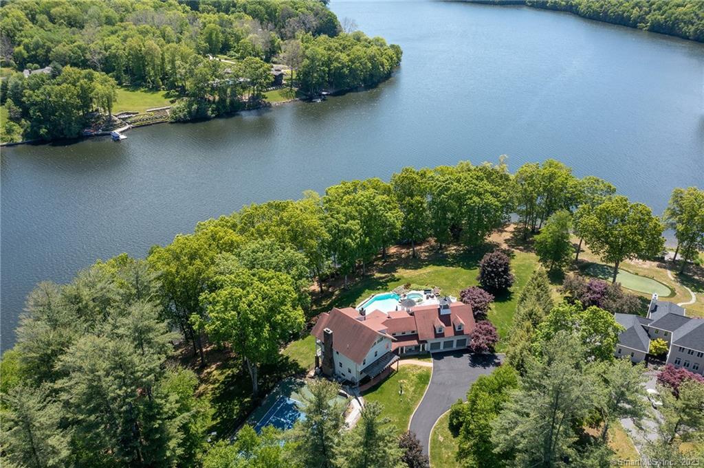 Amazing $295,000 Price Drop! Unique Waterfront Estate, set on 2.5 acs, with 520 ft frontage & over 7580 SF of casually, elegant lake living, on scenic Lake Lillinonah. The Pointe at Barkwood Falls hosts this unique offering w/ intriguing design elements & a grand 5/6 Bedroom, 8 Bath open plan for extended families, guests & fabulous entertainment options. The voluminous great room opens to the renovated kitchen w/white Shaker cabinets, large dining bay & adjacent formal dining room for large private dinner parties. The main level houses 1 of 2 primary bedroom suites w/a new full bath, mantled fplc., WIC w/dressing room & balcony viewing the Lake. Adjacent 1st floor office offers optional sleeping space. On the upper level find a grand primary ste w/stone fplc ,French Doors to a lofty balcony w/covered Gazebo & dynamic lake views. A spiral, stair leads to a 2nd office.The central focus of this level is a gaming area w/pool table. Two additional bedroom suites w/full baths, double closets & balconies offer wide lake views.  The lower level houses a 5th bedroom w/access to a full bath,Family Rm, Gym w/half bath, media rm & wine cellar. A 3 season sunroom leads through 2 sets of sliders to an elevated granite terrace, deck & sweeping lawn. The panoramic views of the lake encompass 270 degree south facing views, Gunite pool, spa, private tennis courts w/covered viewing area & near level lake frontage. Enjoy Lake Living in this Area's Finest Offering! Paradise Found!