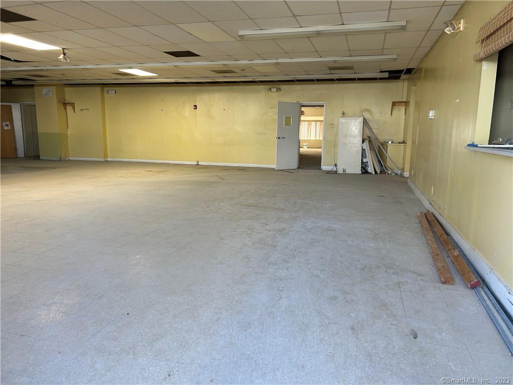 Large open commercial space with two public restrooms, two small offices, and two entry ways. Includes a kitchen area with hood (no other appliances included just a hood). Located on the East Side of Bridgeport. Direct access to I-95 and Route 8. The front tenant will be a pharmacy. Great for small medical office, insurance office, possible commissary kitchen, gym, or social services. Ample street parking and space comes with 3-4 parking spaces.