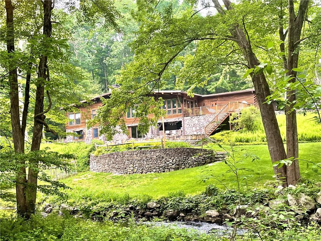 This Adirondack-style, post and beam getaway, overlooking the Aspetuck river, offers endless fun for all~ swim in river, sunbathe on sandy beach, float on docks, kayak/paddle board, play tennis/basketball, frolic on sandy playground, or BBQ in picnic area! Or simply relax at the house on the upper deck, unwind at the patio bar, grill on the Big Green Egg, dine al fresco on the expansive blue stone patio, or roast marshmallows over the fire pit under string lights. Discover this magical escape! Available the month of July and August.