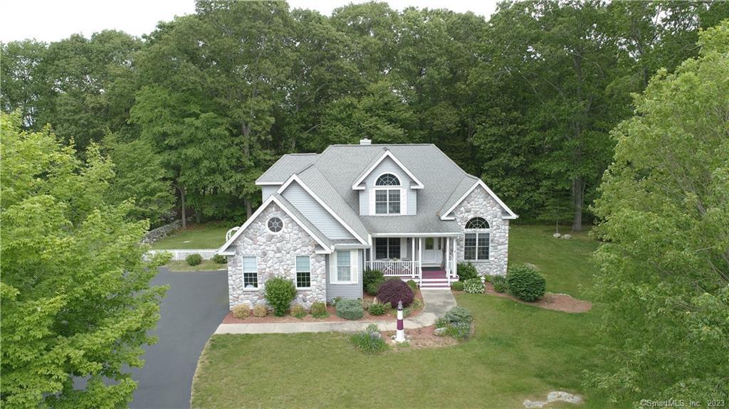 Stunning dormered Contemporary home with lovely porch, 4 bedrooms, 3.5 baths, and 3, 962 sf on 0.92 acres. A spacious kitchen provides ample counterspace and a breakfast bar along with a double sink. A small breakfast nook attached to the kitchen allows for simple and cozy meals, with a formal dining room for larger occasions and guests. The gorgeous stone fireplace will draw you into the living room, serving as an excellent place to relax and entertain, with access to the deck. The library near the entrance can serve as another spot for greeting and visiting guests, and the built in has a desk area that allows the room to function as an office. Primary bedroom on the main floor with full bath and small stained-glass window. Upper level has 3 additional bedrooms, with the largest of them featuring skylights and a small stained-glass window. A massive finished room within the partially finished full basement can serve as a hub of activity in the form of a family room with additional fireplace, but can also be partitioned into multiple smaller rooms if desired. Archways with columns and hardwoods throughout main floor. The home has several windows throughout to allow for natural light to pour in, an attached 3 car garage, and central air.