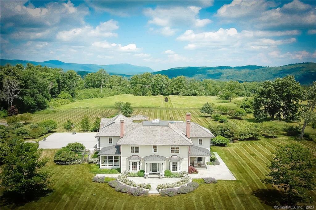 Centennial Oaks - From the idyllic country road to the elegant winding drive through open meadows among ancient oak trees, arriving at the site of this sophisticated country retreat is restorative on its own. The perfect country home: this pristine 6-bedroom, 5-full-bath house features generous sun-filled spaces and high ceilings throughout. Located in a quiet estate area of Lakeville/Salisbury, this architecturally designed, 8, 400+ square feet home on four floors was built in 2010 and renovated in 2012. Appointed with beautiful oak plank floors, handcrafted cabinetry, antique doors, hardware, and mantels, the beautiful, sun-lit interiors include a perfectly proportioned living room with a fireplace; a dining room for family-style gatherings with a wall of cabinetry and fireplace; and an inviting great room with full bar and cabinetry. Perfect for entertaining indoors and out: the sunset porch and broad slate terrace offer space for al fresco dining, complete with an outdoor kitchen, and a raised hearth fireplace. Take in the magical setting from the pool and pool pavilion. Escape to your country's paradise in Salisbury. Close to Millerton, Metro North, Hotchkiss, Lakeville, and Salisbury.