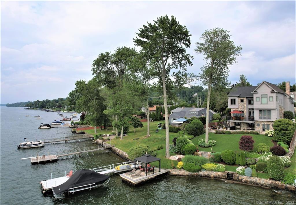IMPECCABLE CANDLEWOOD LAKE WATERFRONT! This home was built with exquisite custom craftsmanship and serene LAKE VIEWS from nearly every room. Thoughtfully designed with the comforts of everyday living and is ideal for entertaining inside & out. The open concept offers a well-designed chef’s kitchen & a large dining room both with Mosaic tile flooring. The oversized great room has a warm fireplace & loads of natural lighting & Brazilian Cherry wood floors. This main level has radiant heated flooring. There is access to the large lakeside deck with breathtaking long lake views. The home faces west with the most amazing sunsets. The expansive lake-level family room has copper ceilings, industrial rubber radiant heated flooring, a warm fireplace, a center bar with a beverage center, an office, a large gym, & a full bath with a steam shower & access to the lakeside patio that will accommodate the largest of gatherings. The gorgeous, landscaped grounds are manicured with stone walls, manicured gardens with mature plantings, perennial gardens, and lush green grass. The lakefront offers easy access to a lakeside bluestone patio with a gazebo, a perfect place to relax after a day on the lake. The deep-water dock is home to your lake toys and the home has a unique free-floating swim platform and an oversized 2-car garage. This incredible Candlewood Lake home is in Candlewood Shores & close to shopping, dining, & schools. LIVE THE DREAM! This home is the best of lakefront living!